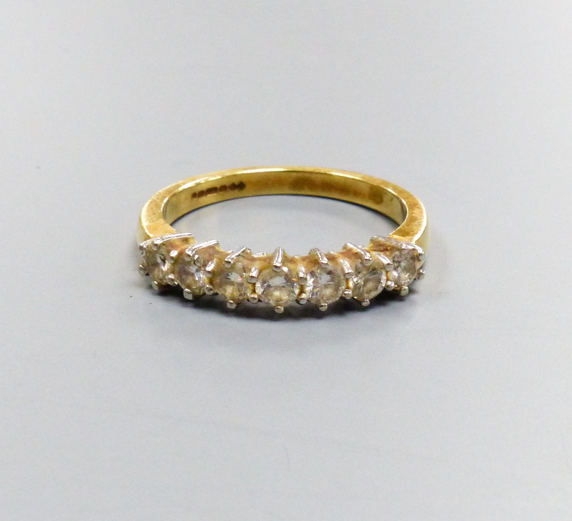 A modern 18ct gold and seven stone diamond set half hoop ring, size P/Q, gross weight 4.4 grams.